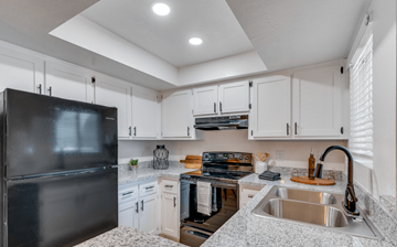 Glendale apartment for rent - A kitchen with a black refrigerator and white cabinets.