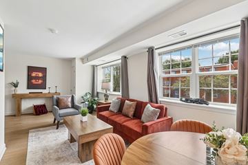 Washington apartment for rent - A living room with a red couch and a wooden table.