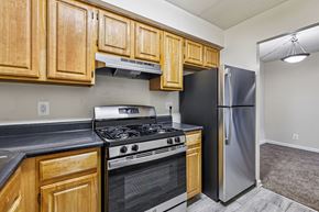 Washington apartment for rent - A kitchen with wooden cabinets and a black refrigerator.