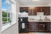 Washington apartment for rent - A kitchen with brown cabinets and a black oven.