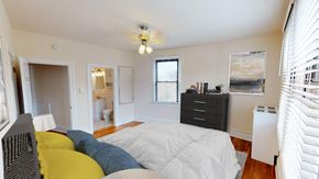 Washington apartment for rent - bedroom with bed, dresser, closet and view of bathroom at the klingle apartments in washignton dc