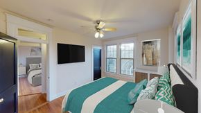Washington apartment for rent - bedroom with bed, dresser, large windows, ceiling fan and tv at the cortland apartments in washington dc