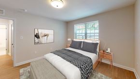 Washington apartment for rent - A bedroom with a bed, nightstand, and a painting on the wall.