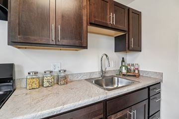 Washington apartment for rent - A kitchen with a marble countertop and wooden cabinets.