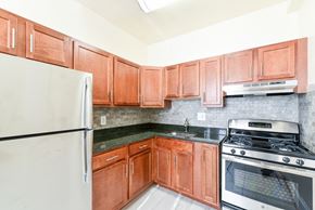Washington apartment for rent - kitchen with wood cabinetry, stainless steel appliances and tile backsplash at the norwood apartments in adams morgan washington dc