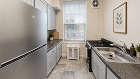 Washington apartment for rent - A modern kitchen with a stainless steel refrigerator and a granite countertop.