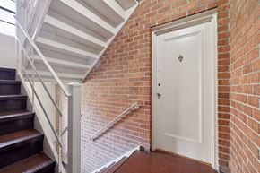 Bethesda apartment for rent - A white door is at the end of a brick wall hallway.