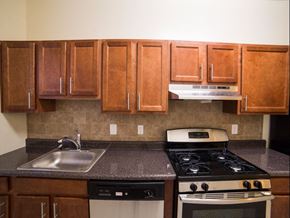 Washington apartment for rent - kitchen with dark wood cabinetry, gas range and tile backsplash  at 2800 ontario road apartments in washington dc