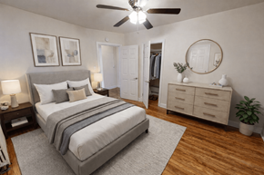 Washington apartment for rent - A bedroom with a large bed, a dresser, and a ceiling fan.