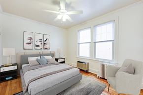 Washington apartment for rent - bedroom with bed, nightstands, sitting area, large windows and ceiling fan at 3213 wisconsin apartments in washington dc