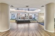 Washington apartment for rent - A spacious room with wooden floors and white columns.