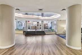 Washington apartment for rent - A spacious room with wooden floors and white columns.