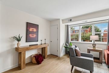 Washington apartment for rent - A living room with a grey couch, a wooden bench, and a painting on the wall.