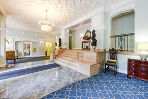 Washington apartment for rent - lobby lounge with social seating, ornate ceiling and stairs leading to elevators at the frontenac apartments in van ness washington dc