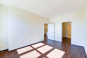 Washington apartment for rent - vacant bedroom with hardwood flooring, closet and view of bathroom at archer park apartments in washington dc