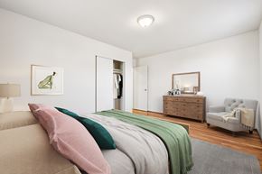 Bethesda apartment for rent - A bedroom with a bed, a dresser, a mirror, and a chair.