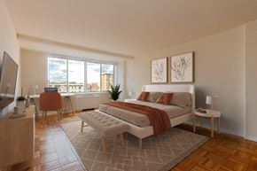 Washington apartment for rent - A modern bedroom with a large bed and a television.