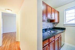 Bethesda apartment for rent - kitchen with wood cabinetry, tile backsplash, and window at cambridge square apartments in bethesda md