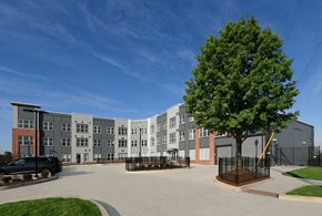 Washington apartment for rent - A large grey building with a black car parked in front.