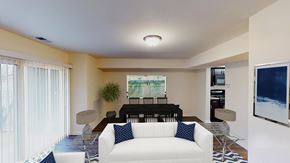 Washington apartment for rent - living area with sofa, coffee table, large patio doors and view of dining area at city towns apartments in washington dc