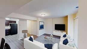 Washington apartment for rent - living area with sofa, coffee table, large patio doors, tv, credenza and view of kitchen at city towns apartments in washington dc