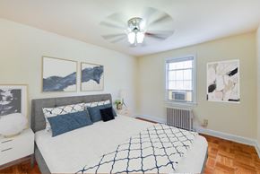 Washington apartment for rent - bedroom with bed, nightstands, ceiling fan, large closet and hardwood flooring at colonnade apartments in washington dc