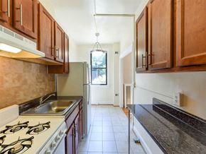 Washington apartment for rent - kitchen with wood cabinetry and tile backsplash at the klingle apartments in washignton dc