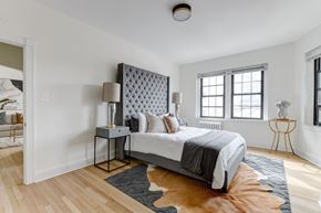 Washington apartment for rent - bedroom with bed, nightstand, large windows and hard wood floors at the dahlia apartments in washington dc