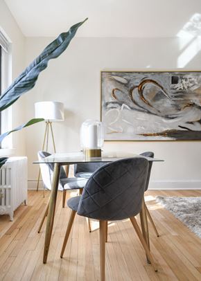 Washington apartment for rent - dining area with table chairs, houseplants, modern artwork and hardwood flooring at the dahlia apartments in washington dc