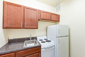 Washington apartment for rent - kitchen with wood cabinetry, electric range and refrigerator at eddystone apartments in washington dc