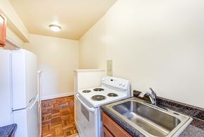 Washington apartment for rent - kitchen with wood cabinetry, electric range and refrigerator at eddystone apartments in washington dc