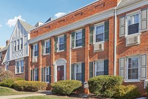 Chevy Chase apartment for rent - A red brick building with green shutters and a white door.