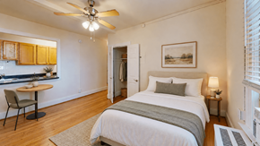 Washington apartment for rent - A bedroom with a bed, a chair, and a painting on the wall.