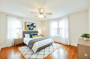 Washington apartment for rent - A bedroom with a bed, nightstands, and a ceiling fan.