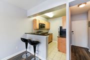 Washington apartment for rent - A kitchen with a bar stool and a microwave above the bar.