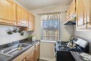 Washington apartment for rent - A kitchen with wooden cabinets and a black stove top oven.