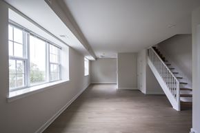 Washington apartment for rent - A long hallway with a staircase on the right and windows on the left.
