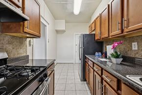 Washington apartment for rent - A kitchen with a black refrigerator and wooden cabinets.