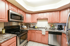 Washington apartment for rent - A kitchen with pink cabinets and stainless steel appliances.