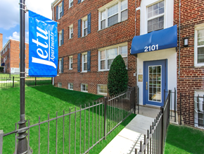 Washington apartment for rent - exterior of jetu apartments with lush landscaping, brick building and sidewalk in washington dc