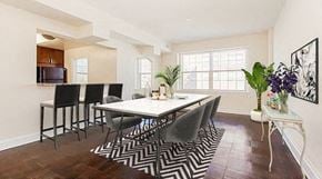 Washington apartment for rent - dining area with table, chairs, large windows, and view of kitchen with breakfast bar at juniper courts apartments
