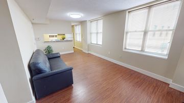 Washington apartment for rent - A living room with a blue couch and wooden floors.