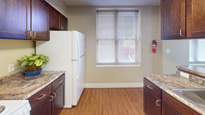 Washington apartment for rent - A kitchen with brown cabinets and a white fridge.