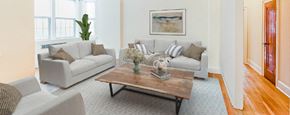 Washington apartment for rent - living area with sofa, coffee table, hardwood floors, large windows and ceiling fan  at 2800 ontario road apartments in washington dc