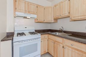 Washington apartment for rent - kitchen with wood cabinetry, gas range and tile flooring at parkside apartments in washington dc