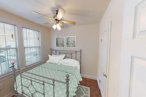 Washington apartment for rent - bedroom with bed, large windows, hardwood flooring and ceiling fan at parkside apartments in washington dc