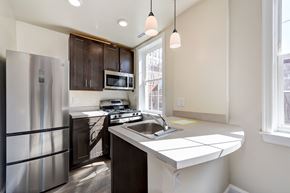 Washington apartment for rent - kitchen with espresso cabinetry, breakfast bar and stainless steel appliances at petworth station apartments in washington dc