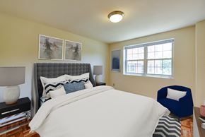 Washington apartment for rent - bedroom with bed, nightstands, parquet flooring and large window at shipley park apartments in washington dc