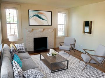 Chevy Chase apartment for rent - A living room with a fireplace and a painting above it.