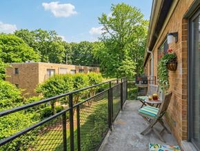 Washington apartment for rent - A balcony with a table and chairs overlooks a green yard.